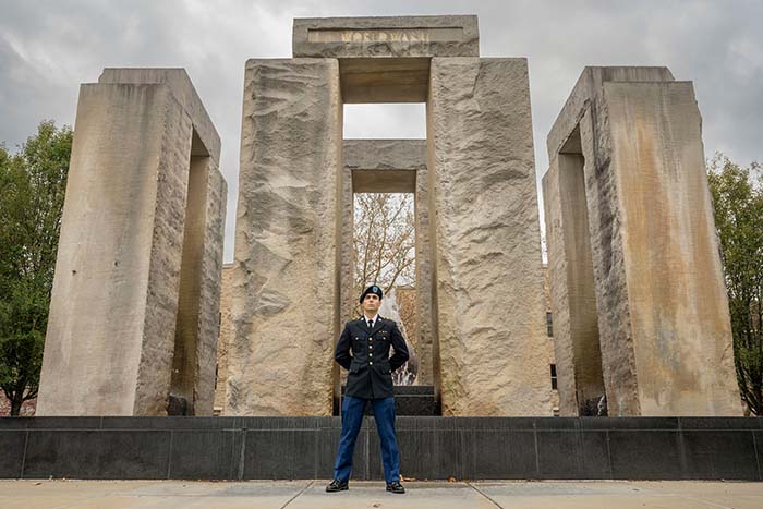 An ROTC student stands vigil in front of the monument on campus